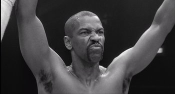 Movie still from “The Hurricane” (1999), directed by Norman Jewison – A black and white photo of a man with his hands raised; Close Up shot, Low angle