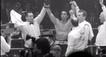 Movie still from “The Hurricane” (1999), directed by Norman Jewison – A black - and - white photo of a man in a boxing ring holding his hands up; Medium shot, Low angle