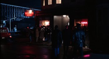Movie still from “The Hurricane” (1999), directed by Norman Jewison – A group of people standing on the sidewalk in front of a building; Extreme Wide shot, High angle