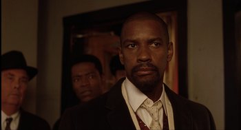 Movie still from “The Hurricane” (1999), directed by Norman Jewison – A man in a suit standing next to another man in a suit; Close Up shot, Over the shoulder angle