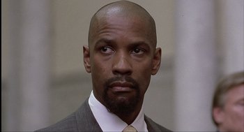 Movie still from “The Hurricane” (1999), directed by Norman Jewison – A man in a suit and tie with a bald head; Close Up shot, Low angle