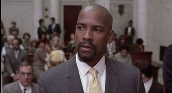 Movie still from “The Hurricane” (1999), directed by Norman Jewison – A man in a gray suit and a yellow tie; Close Up shot, Low angle