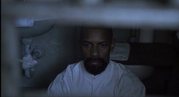 Movie still from “The Hurricane” (1999), directed by Norman Jewison – A man in a white shirt is looking at the camera; Close Up shot, High angle