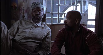 Movie still from “The Hurricane” (1999), directed by Norman Jewison – Two men sitting next to each other in front of a window; Medium shot, Low angle