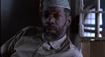 Movie still from “The Hurricane” (1999), directed by Norman Jewison – A person with a beard wearing a hat; Close Up shot, Low angle