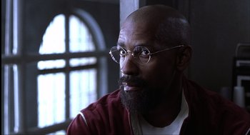 Movie still from “The Hurricane” (1999), directed by Norman Jewison – A man with a goatee wearing glasses and a red jacket; Close Up shot, Low angle
