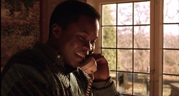 Movie still from “The Hurricane” (1999), directed by Norman Jewison – A man talking on a phone while sitting in front of a window; Close Up shot, Low angle