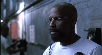 Movie still from “The Hurricane” (1999), directed by Norman Jewison – A man with a beard and glasses looking to his left; Close Up shot, Low angle