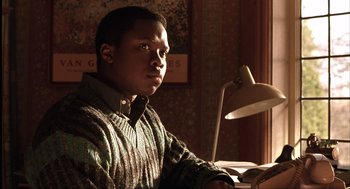 Movie still from “The Hurricane” (1999), directed by Norman Jewison – A man sitting at a desk in front of a lamp; Close Up shot, High angle