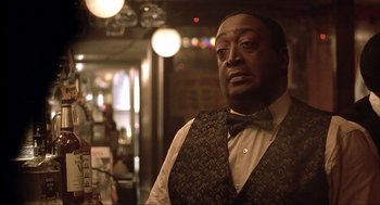 Movie still from “The Hurricane” (1999), directed by Norman Jewison – A man wearing a vest and a bow tie in a restaurant; Close Up shot, Over the shoulder angle