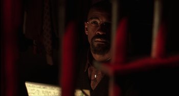 Movie still from “The Hurricane” (1999), directed by Norman Jewison – A person wearing glasses in a dark room; Close Up shot, Over the shoulder angle