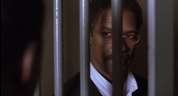 Movie still from “The Hurricane” (1999), directed by Norman Jewison – A person behind a metal fence; Close Up shot, Over the shoulder angle