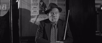 Movie still from “The Hustler” (1961), directed by Robert Rossen – An older man smoking a cigarette while holding a pool cue; Medium shot, Low angle