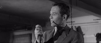 Movie still from “The Hustler” (1961), directed by Robert Rossen – A black and white photo of a man smoking a pipe; Close Up shot, Low angle