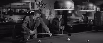 Movie still from “The Hustler” (1961), directed by Robert Rossen – Two men are playing a game of billiards; Medium shot, High angle