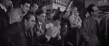 Movie still from “The Hustler” (1961), directed by Robert Rossen – A group of men sitting next to each other on steps; Medium shot, High angle