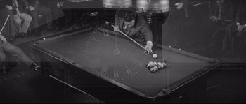 Movie still from “The Hustler” (1961), directed by Robert Rossen – A man is playing a game of billiards; Medium shot, High angle