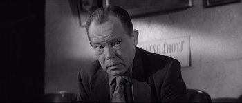 Movie still from “The Hustler” (1961), directed by Robert Rossen – An older man in a suit and tie; Close Up shot, Low angle