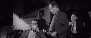 Movie still from “The Hustler” (1961), directed by Robert Rossen – Two men in suits and ties are drinking coffee; Medium shot, Low angle