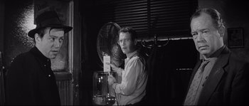 Movie still from “The Hustler” (1961), directed by Robert Rossen – A black and white photo of a man holding a fan; Medium shot, Low angle