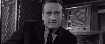 Movie still from “The Hustler” (1961), directed by Robert Rossen – Black and white photograph of a man wearing a suit and tie; Close Up shot, Low angle