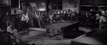 Movie still from “The Hustler” (1961), directed by Robert Rossen – A group of men sitting around a pool table; Wide shot, High angle