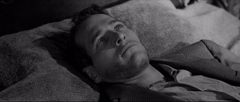 Movie still from “The Hustler” (1961), directed by Robert Rossen – Black and white photograph of a man laying on a couch; Close Up shot, High angle