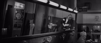 Movie still from “The Hustler” (1961), directed by Robert Rossen – A man sitting in front of a mirror in a dressing room; Medium shot, High angle