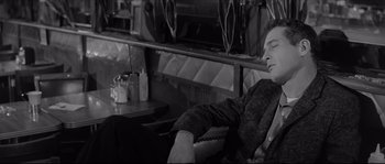 Movie still from “The Hustler” (1961), directed by Robert Rossen – A black and white photo of a man sitting in a chair; Medium shot, High angle