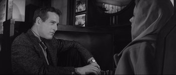 Movie still from “The Hustler” (1961), directed by Robert Rossen – A black and white photo of a man sitting at a table; Close Up shot, Over the shoulder angle