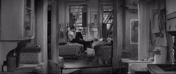 Movie still from “The Hustler” (1961), directed by Robert Rossen – A man sitting on top of a bed next to a woman; Wide shot, High angle