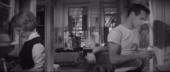 Movie still from “The Hustler” (1961), directed by Robert Rossen – A man sitting in a living room next to a window; Medium shot, Over the shoulder angle