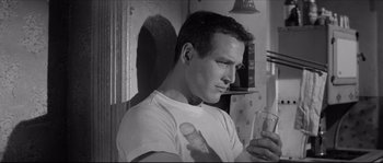 Movie still from “The Hustler” (1961), directed by Robert Rossen – A black and white photo of a man holding a glass; Close Up shot, Low angle