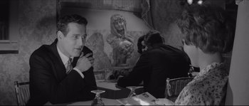 Movie still from “The Hustler” (1961), directed by Robert Rossen – A black - and - white photo of people sitting at a table; Medium shot, Over the shoulder angle