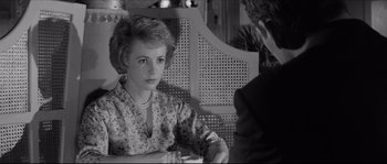Movie still from “The Hustler” (1961), directed by Robert Rossen – A woman sitting at a table with a glass of wine; Close Up shot, Over the shoulder angle