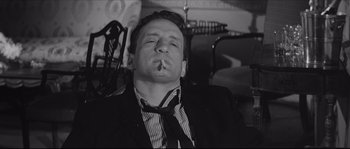 Movie still from “The Hustler” (1961), directed by Robert Rossen – A black and white photo of a man smoking a cigarette; Close Up shot, Low angle