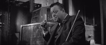 Movie still from “The Hustler” (1961), directed by Robert Rossen – A man smoking a cigarette while sitting down; Close Up shot, Low angle