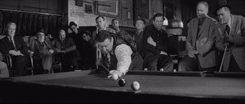 Movie still from “The Hustler” (1961), directed by Robert Rossen – A man playing pool in front of a group of people; Medium shot, High angle