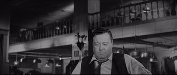 Movie still from “The Hustler” (1961), directed by Robert Rossen – A black and white photo of a man in a suit and tie; Medium shot, Low angle