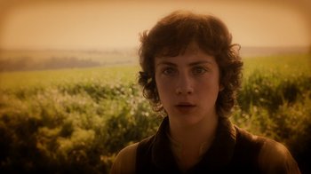 Movie still from “The Illusionist” (2006), directed by Neil Burger – A young man in a field of flowers looking into the distance; Close Up shot, Low angle