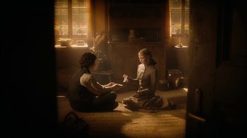 Movie still from “The Illusionist” (2006), directed by Neil Burger – Two people sitting on the ground in a room; Medium shot, High angle