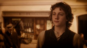 Movie still from “The Illusionist” (2006), directed by Neil Burger – A young man standing in front of a room; Close Up shot, Over the shoulder angle
