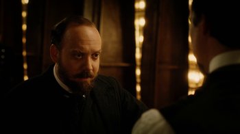 Movie still from “The Illusionist” (2006), directed by Neil Burger – A man with a goatee and beard sitting in front of a mirror; Close Up shot, Over the shoulder angle