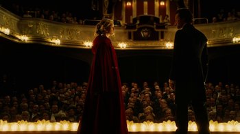 Movie still from “The Illusionist” (2006), directed by Neil Burger – A man and a woman are standing in front of an audience; Wide shot, Over the shoulder angle