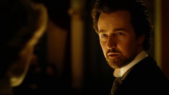 Movie still from “The Illusionist” (2006), directed by Neil Burger – A person wearing a suit and tie; Close Up shot, Low angle
