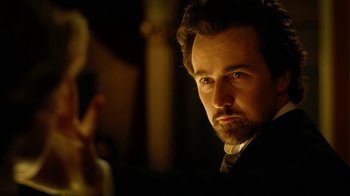 Movie still from “The Illusionist” (2006), directed by Neil Burger – A person wearing a suit and tie; Close Up shot, Low angle