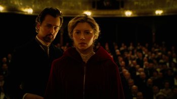Movie still from “The Illusionist” (2006), directed by Neil Burger – A man and a woman standing in front of an audience; Medium shot, Low angle