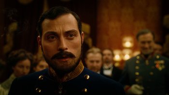 Movie still from “The Illusionist” (2006), directed by Neil Burger – A person with a mustache wearing a uniform; Close Up shot, Over the shoulder angle