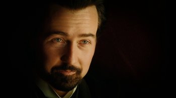 Movie still from “The Illusionist” (2006), directed by Neil Burger – A person wearing a suit and tie; Close Up shot, Low angle