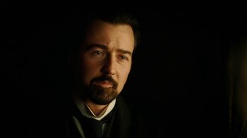 Movie still from “The Illusionist” (2006), directed by Neil Burger – A person wearing a suit and tie; Close Up shot, Low angle